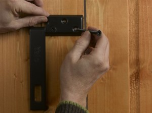 inserting bolts or screws to secure the hasp plate