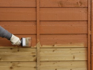 painting fence with brush